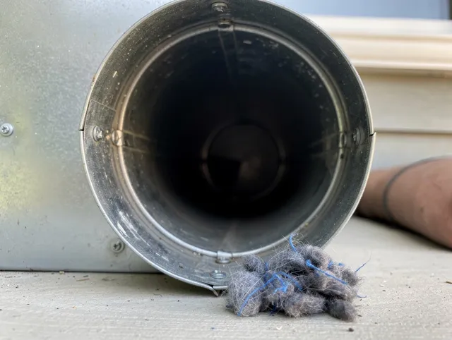 Norfolk Dryer Vent Cleaning technician using specialized equipment to clear severe dryer vent blockage in Norfolk